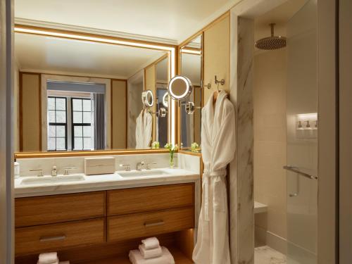 a bathroom with two sinks and a large mirror at The Surrey, A Corinthia Hotel in New York