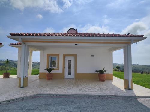 a small white building with two potted plants at Natural Park Heights in São João das Lampas