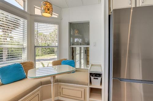 a kitchen with a table and a refrigerator at 3 Mi to Nokomis Beach Resort Home in Florida in Nokomis