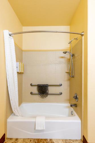 a bath tub in a bathroom with yellow walls at Hotel Texas Hallettsville in Hallettsville