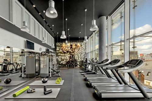 a gym with rows of treadmills and machines at W London in London