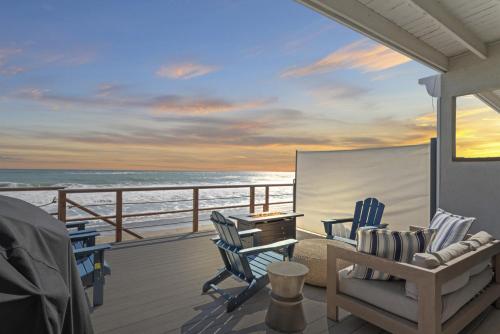 a balcony with chairs and a desk and the ocean at Private beach toes on the Sand Waterworld in Dana Point