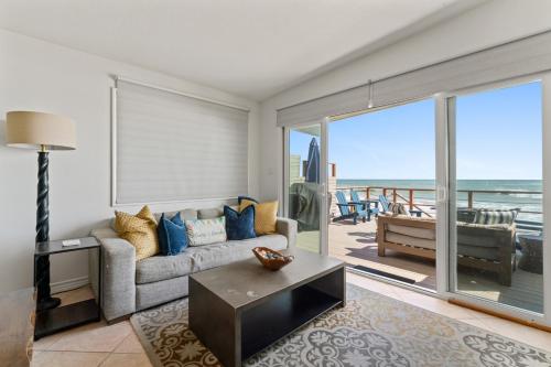 a living room with a couch and a view of the ocean at Private beach toes on the Sand Waterworld in Dana Point