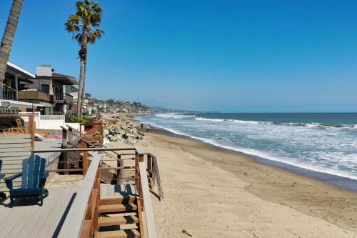a beach with chairs and palm trees and the ocean at Private beach toes on the Sand Waterworld in Dana Point