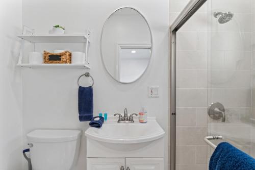 a bathroom with a toilet and a sink and a mirror at Private beach toes on the Sand Waterworld in Dana Point