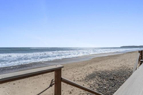 a view of the beach from a wooden railing at Private beach toes on the Sand Waterworld in Dana Point