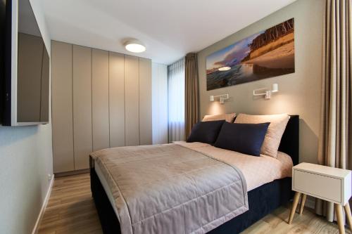a small bedroom with a bed and a tv at Forest Apartment in Pobierowo