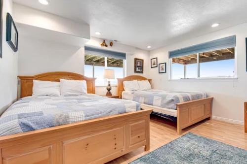 two beds in a bedroom with two windows at Sail Boat Manor in Garden City