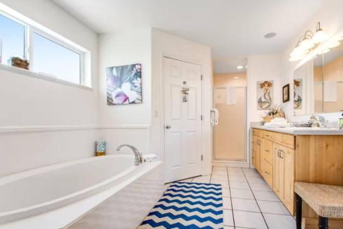 a bathroom with a tub and a sink at Sail Boat Manor in Garden City