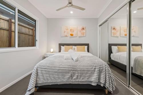 a bedroom with a bed and a ceiling fan at Modern 4BR Home Peaceful Logan Reserve Stay in Buccan