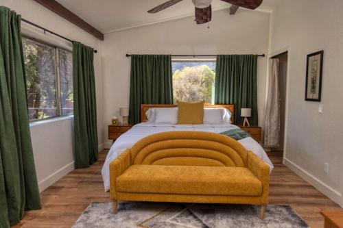 a bedroom with a large bed with green curtains at Peaceful Desert Hideaway in Sedona