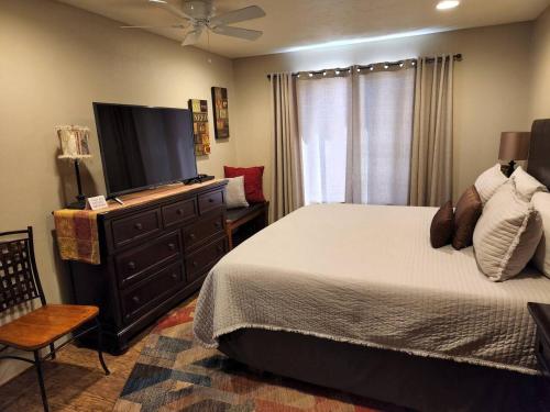 a bedroom with a bed and a flat screen tv at Johnnys Sedona Getaway 2 Primary Suites 2 Bath in Sedona