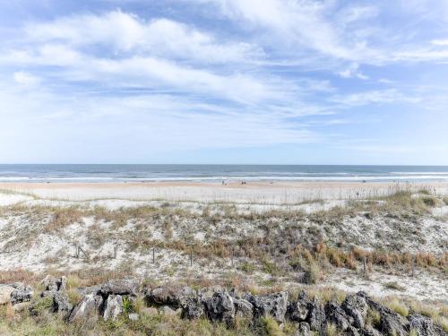 a beach with rocks and the ocean in the background at Surfside Six E Unit 5 in St. Augustine