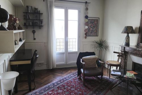 un salon avec une table et des chaises et une fenêtre dans l'établissement Nice 2 rooms in the Quartier Charonne Paris, à Paris
