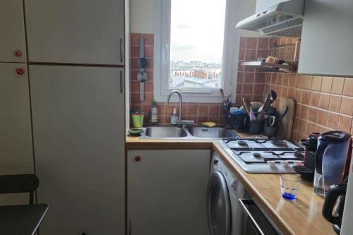une cuisine avec un évier et une cuisinière dans l'établissement Nice 2 rooms in the Quartier Charonne Paris, à Paris