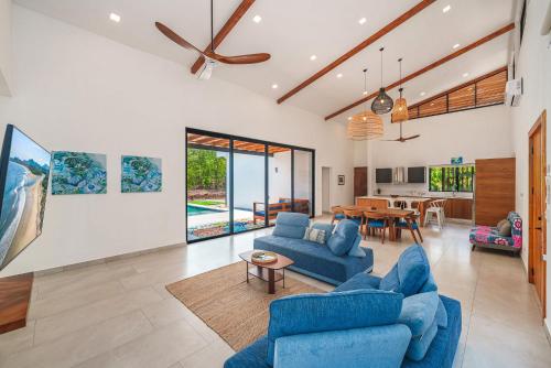a living room with blue couches and a table at Stylish Private Tropical Escape-10 mins from Tamarindo in Villarreal