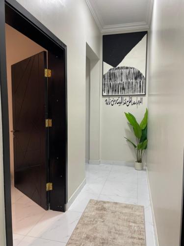 a hallway with a black door and a potted plant at شقة بغرفتين نوم - 2bedrooms apartment in Jazan
