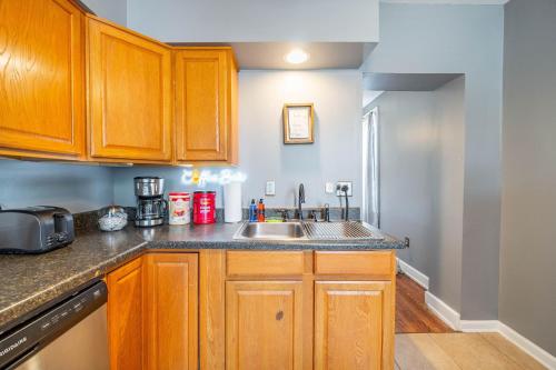 a kitchen with wooden cabinets and a sink at Cozy Brick-Short North Condo - (fenced yard) - OSU in Milo