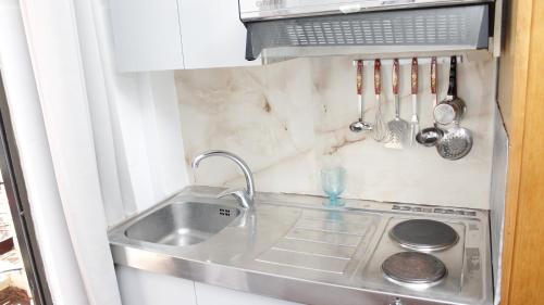 a small kitchen with a sink and a sink at StudioAretiCom Studio to rent in FRONT the lovely SEA fully equipped plagiastudioseu in Nea Plagia