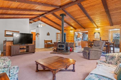 a living room with a tv and a table at Mountain Retreat Woodburning Fireplace Games in Big Bear City
