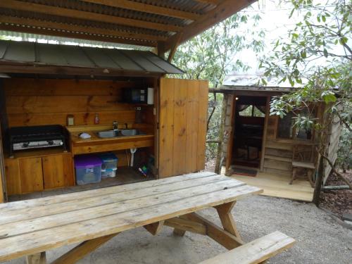 a wooden picnic table in front of a cabin at Linville Falls Campground, RV Park, and Cabins in Linville Falls