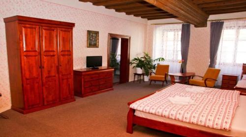 a bedroom with a bed and a cabinet and a television at Kajovska 64 in Český Krumlov