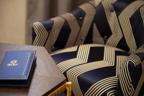 a book sitting on a table next to chairs at Gorash Hotel in Khamis Mushayt