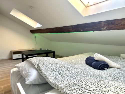 a bedroom with a bed and a table with a window at Le Graoully in Metz