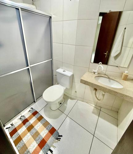 a bathroom with a toilet and a sink at Ap Conforto no Centro de Sinop in Sinop