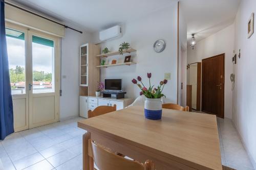 a kitchen with a table with a vase of flowers on it at Lido Beach Escape with Balcony x5! in Lido di Pomposa