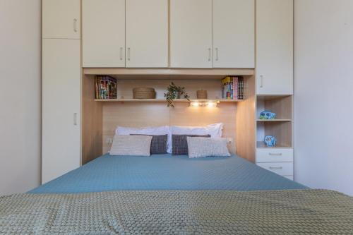 a bedroom with a large bed with white cabinets at Lido Beach Escape with Balcony x5! in Lido di Pomposa