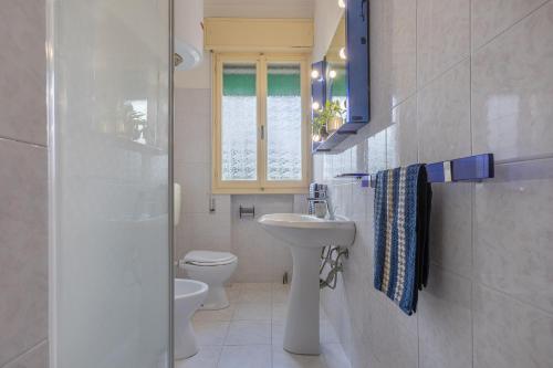 a bathroom with a sink and a toilet and a window at Lido Beach Escape with Balcony x5! in Lido di Pomposa