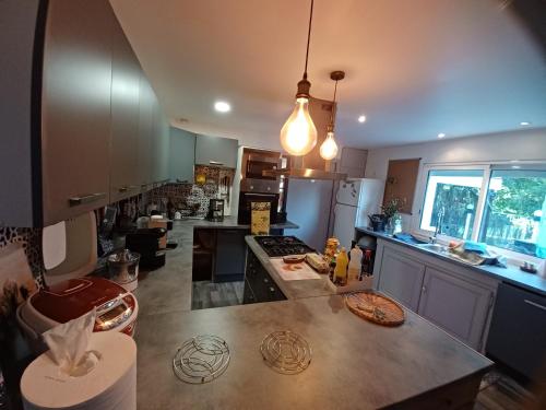 cocina grande con encimera y isla de cocina en La madeleine 1, en Caussade