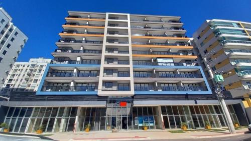 a tall apartment building with a lot of windows at Estúdio 908: conforto e sofisticação no coração de Jardim Camburi in Vitória