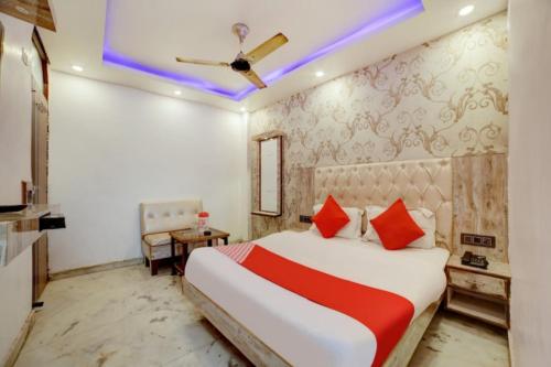 Un dormitorio con una cama grande con almohadas rojas. en Hotel O ROYAL KING HOTEL, en Meerut
