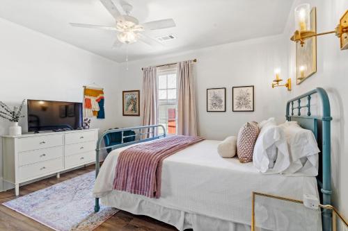 a bedroom with a bed with a ceiling fan and a tv at Suite C Beach, Firepit, Dog-friendly, Downtown! in Biloxi