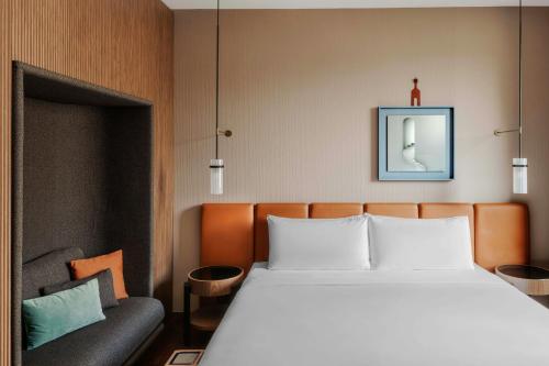 a bedroom with a large bed and a couch at Casa Brera, a Luxury Collection Hotel, Milan in Milan