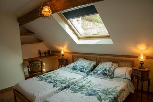 une chambre avec un lit et une lucarne dans l'établissement Songbird Sanctuary, à Civray-de-Touraine