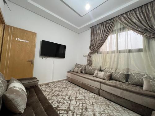 a living room with a couch and a window at Bel appartement à deux pas de la plage in Agadir