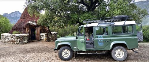 a green jeep parked in front of a building at S'Enis Monte Maccione in Oliena