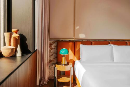 a bedroom with a bed and a table with a lamp at Casa Brera, a Luxury Collection Hotel, Milan in Milan