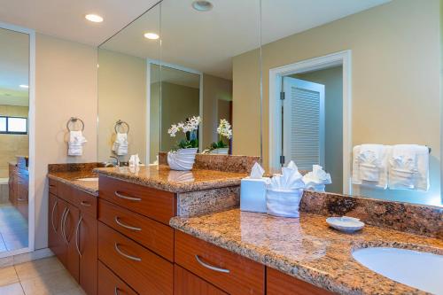 un bagno con due lavandini e un grande specchio di Kapalua Ridge Villas-#2212 by Coldwell Banker Island Vacations a Kahana