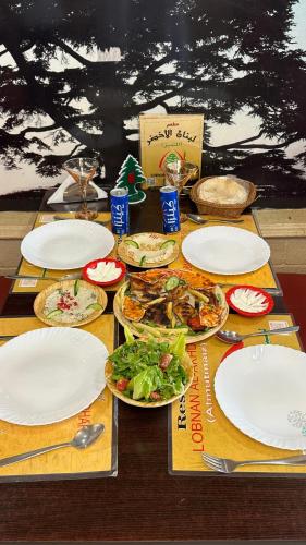 a wooden table with plates of food on it at Marina H in Sohar