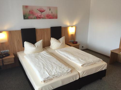 a bedroom with a bed with white sheets and pillows at Chiemgau Appartements in Inzell
