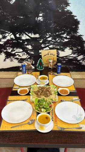 a wooden table with plates of food on it at Marina Town in Sohar