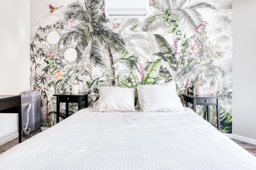 una camera da letto con un letto e carta da parati tropicale di Disney World a Villeneuve-le-Comte
