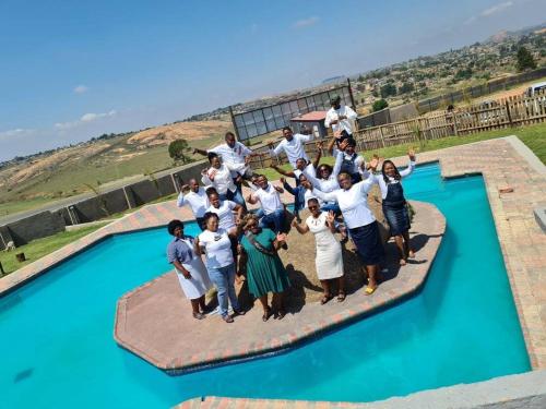 a group of people posing for a picture in front of a pool at The Essence Resort in Clarence