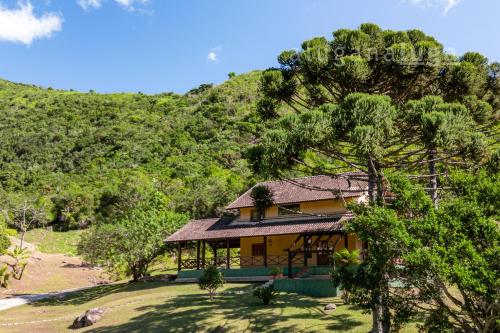 a house in the middle of a hill with trees at Mansão da Imperatriz: Vintage, Termas e Natureza in Santo Amaro da Imperatriz
