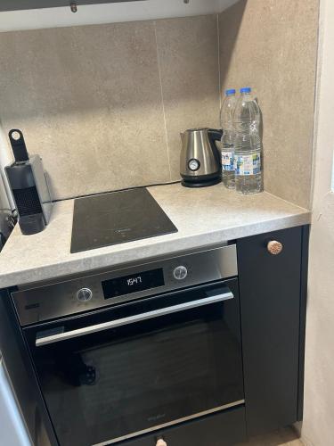 a kitchen with a stove and two bottles of water at The Hideaway in Arminou