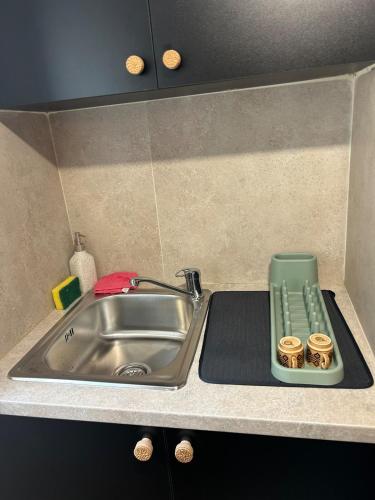 a kitchen sink with a green tray next to it at The Hideaway in Arminou